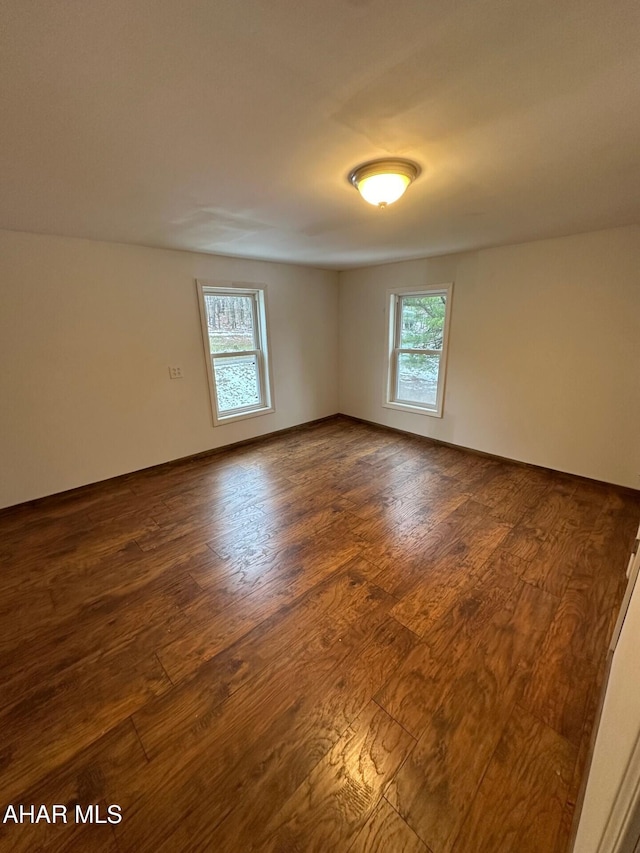 empty room with dark hardwood / wood-style flooring