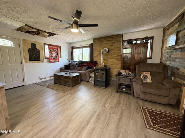 229 Celtic Ln, Altoona, PA 16601 - living room featuring ceiling fan, a wood stove, a textured ceiling, baseboards, and wood finished floors