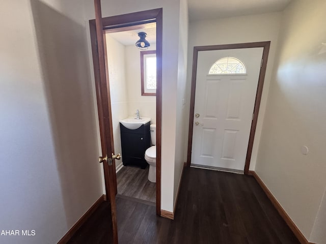 doorway with tile walls, sink, and dark hardwood / wood-style floors