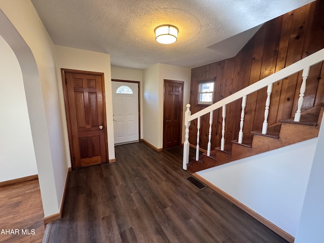 foyer with dark wood-type flooring and a textured ceiling