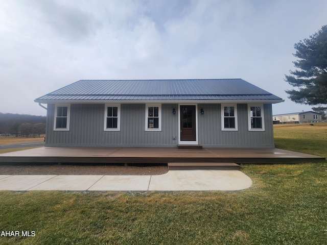 view of front facade with metal roof and a front yard