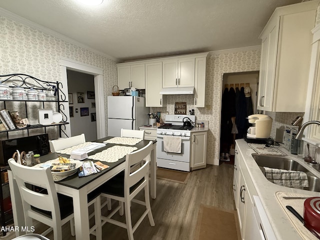 4815 6th Ave, Altoona, PA 16602 - kitchen with white appliances, wallpapered walls, dark wood-style flooring, light countertops, and white cabinetry