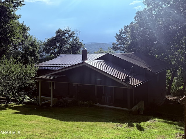 4815 6th Ave, Altoona, PA 16602 - back of house with a chimney, a yard, a metal roof, and a standing seam roof