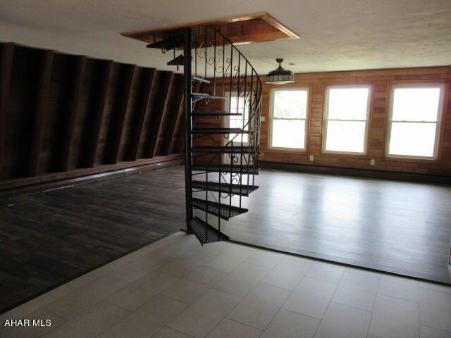 stairs featuring wood-type flooring and a textured ceiling