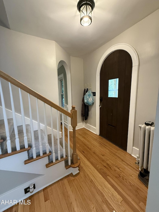 5 Log Cabin Ct, Altoona, PA 16602 - entryway with arched walkways, radiator heating unit, wood finished floors, and stairs