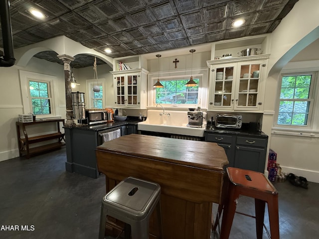 5 Log Cabin Ct, Altoona, PA 16602 - kitchen with arched walkways, stainless steel microwave, an ornate ceiling, healthy amount of natural light, and glass insert cabinets