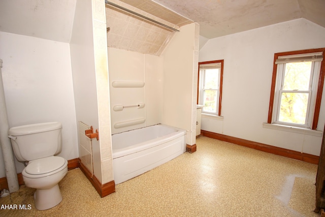 bathroom featuring a healthy amount of sunlight, toilet, and lofted ceiling