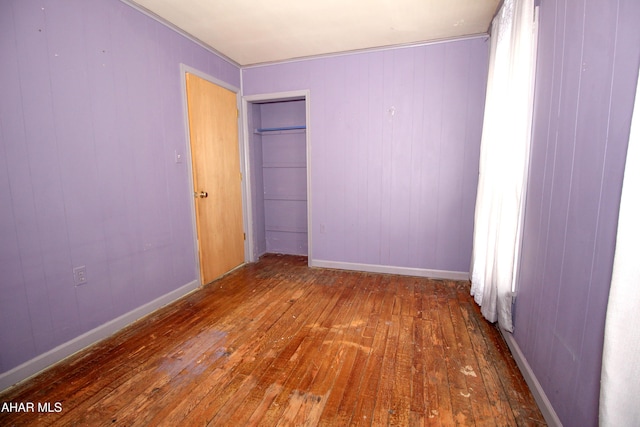 empty room with dark hardwood / wood-style flooring and wooden walls