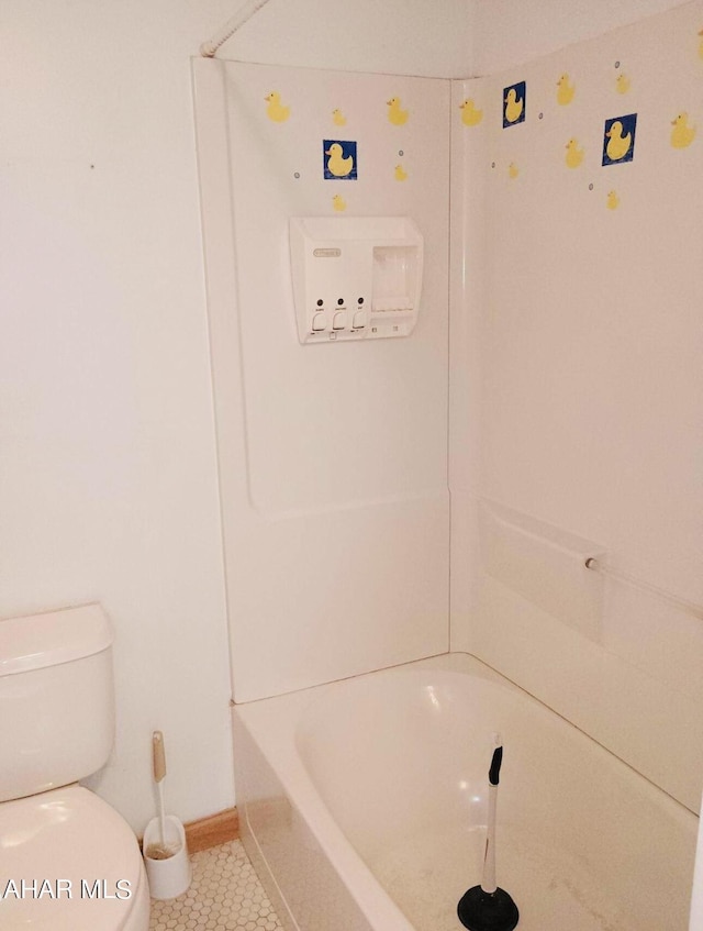 bathroom featuring tile patterned floors, a bathtub, and toilet