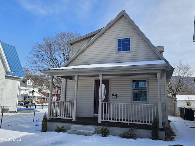 view of front facade featuring covered porch and fence