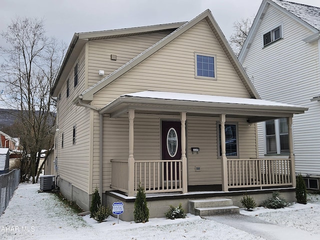 view of front of house with central AC, a porch, and fence