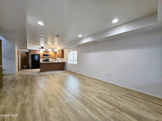 unfurnished living room with baseboards, ceiling fan, recessed lighting, and light wood-style floors