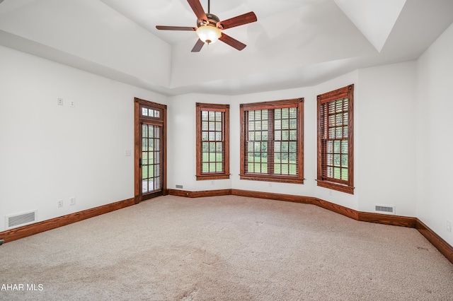 empty room featuring carpet, ceiling fan, and a healthy amount of sunlight