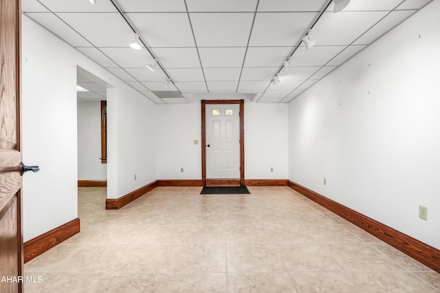 interior space featuring a paneled ceiling, light tile patterned floors, and rail lighting