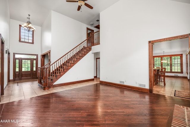 living room featuring hardwood / wood-style floors, high vaulted ceiling, and ceiling fan with notable chandelier