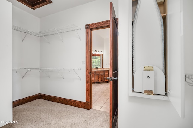 spacious closet featuring light colored carpet