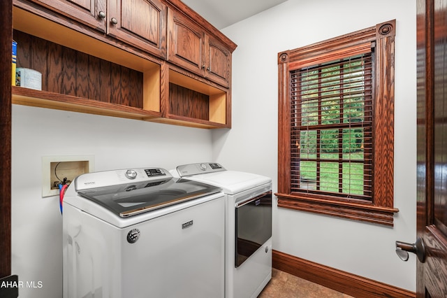 washroom featuring washer and dryer, cabinets, and light tile patterned floors