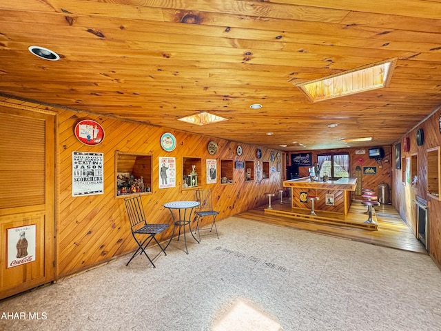 interior space with a skylight, wooden walls, and wood ceiling