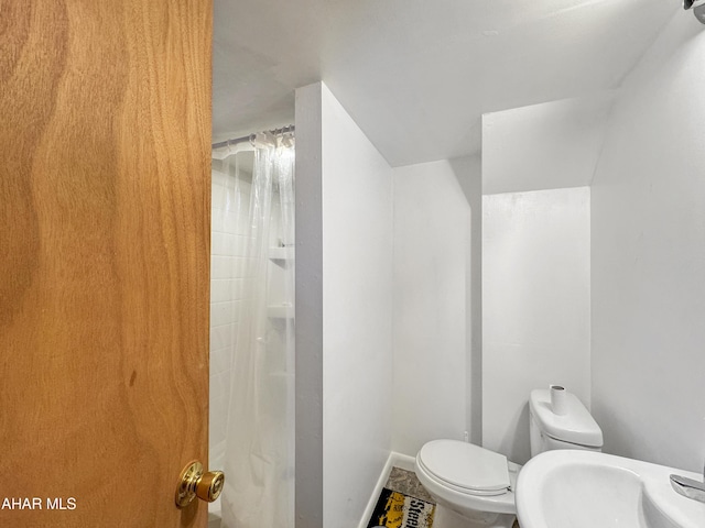 bathroom with a shower with curtain, toilet, and sink