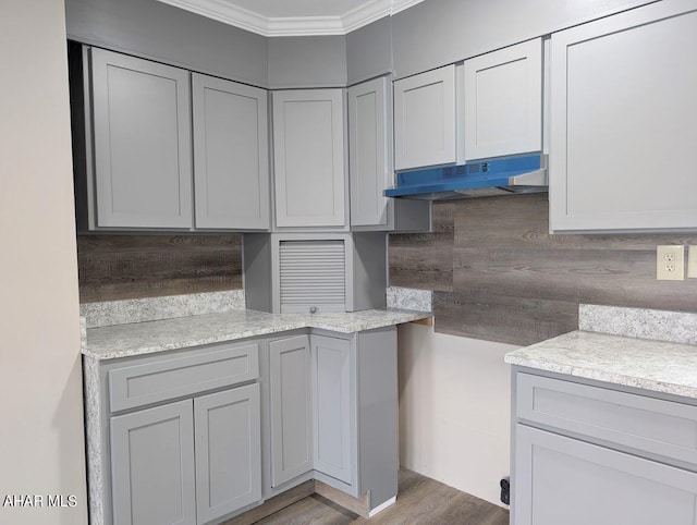 kitchen with gray cabinetry, light hardwood / wood-style floors, and ornamental molding