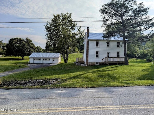 view of front of home featuring an outbuilding, a garage, a front lawn, and a deck