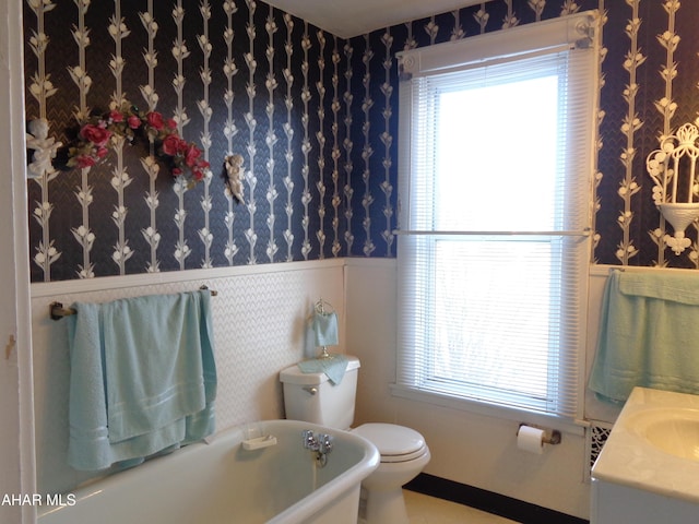 bathroom with vanity, a tub, and toilet