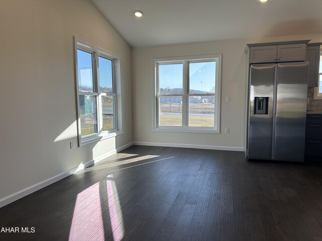 kitchen featuring dark hardwood / wood-style flooring, stainless steel appliances, vaulted ceiling, and a kitchen island