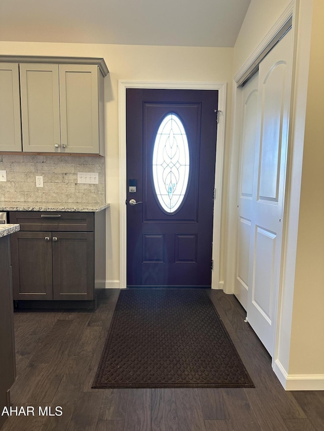 entryway with dark hardwood / wood-style flooring and lofted ceiling