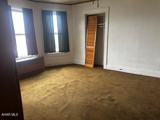 600 N 6th Ave, Altoona, PA 16601 - unfurnished bedroom with carpet flooring, multiple windows, a closet, and radiator heating unit