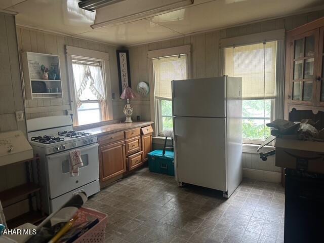 600 N 6th Ave, Altoona, PA 16601 - kitchen with white appliances, healthy amount of natural light, brown cabinets, light countertops, and wood walls