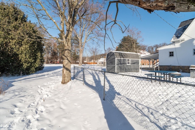 yard layered in snow with a shed