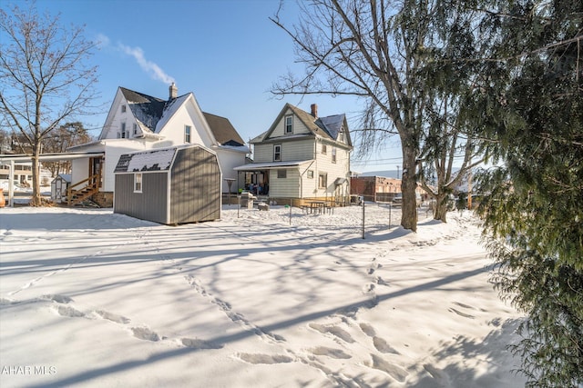 snow covered property featuring a storage shed