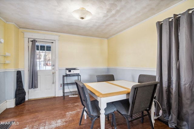 dining area with ornamental molding and dark wood-type flooring