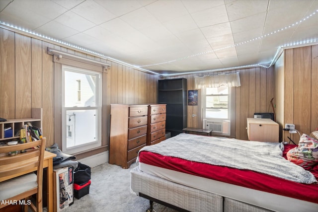 carpeted bedroom with multiple windows, cooling unit, and wood walls