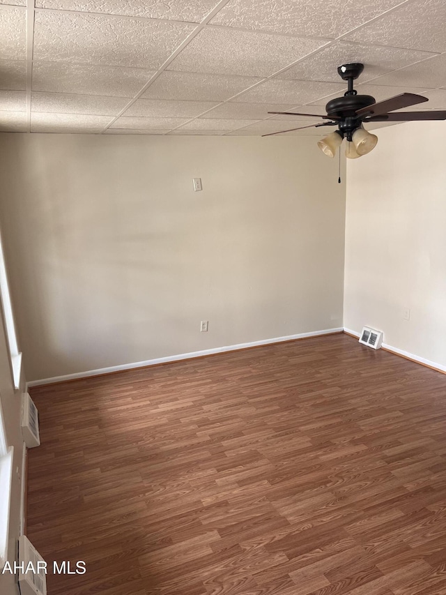 spare room featuring a ceiling fan, wood finished floors, and baseboards