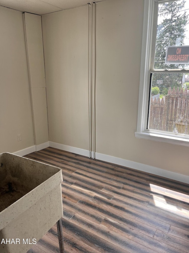 empty room featuring dark wood-style floors and baseboards