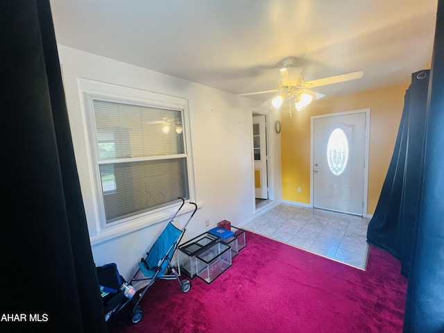 carpeted entryway with ceiling fan