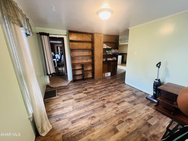 interior space with wood-type flooring and ornamental molding