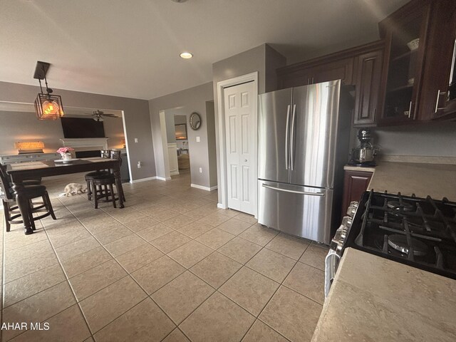 215 Red Fox Dr, Duncansville, PA 16635 - kitchen featuring freestanding refrigerator, light tile patterned floors, dark brown cabinetry, gas range, and a ceiling fan