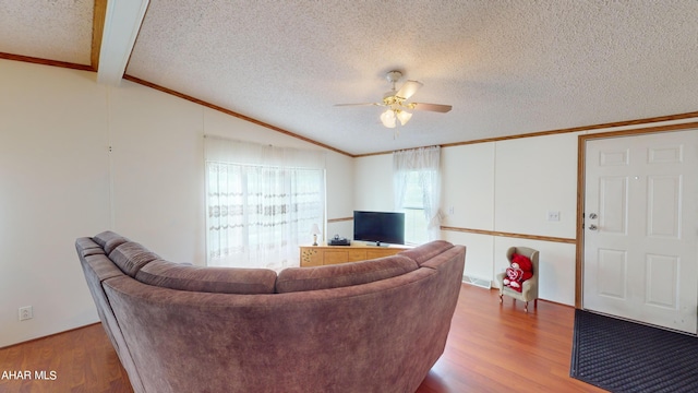 living room featuring a textured ceiling, lofted ceiling with beams, and hardwood / wood-style flooring