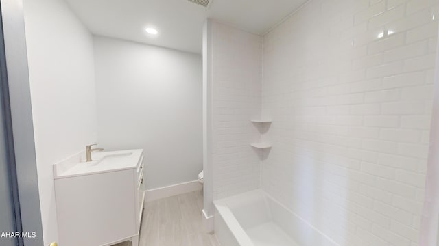 bathroom with vanity, toilet, and a tile shower