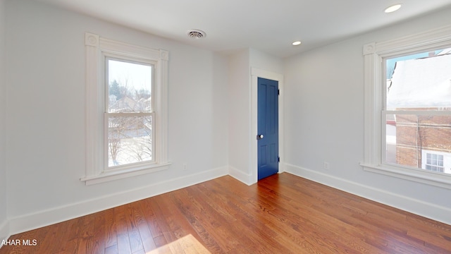 unfurnished room with plenty of natural light and hardwood / wood-style floors