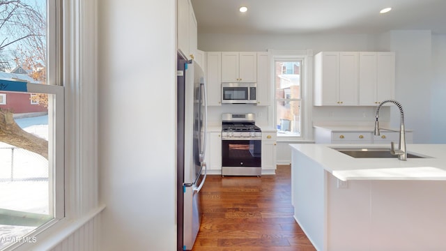 kitchen featuring white cabinetry, appliances with stainless steel finishes, dark hardwood / wood-style floors, and sink