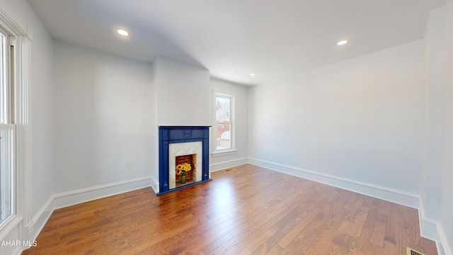 unfurnished living room with hardwood / wood-style flooring and a fireplace