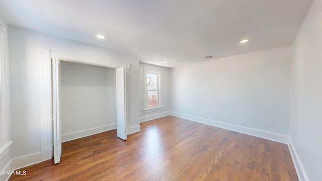 unfurnished bedroom with dark hardwood / wood-style flooring and a closet