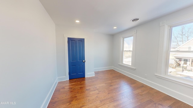 unfurnished room with hardwood / wood-style floors and plenty of natural light