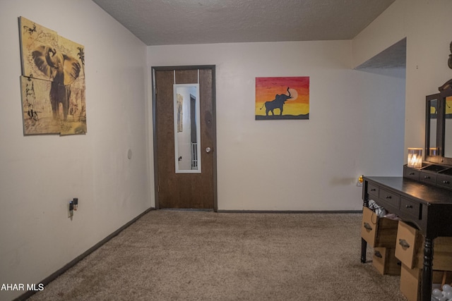 corridor featuring a textured ceiling and light colored carpet