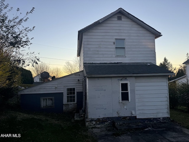 view of back house at dusk