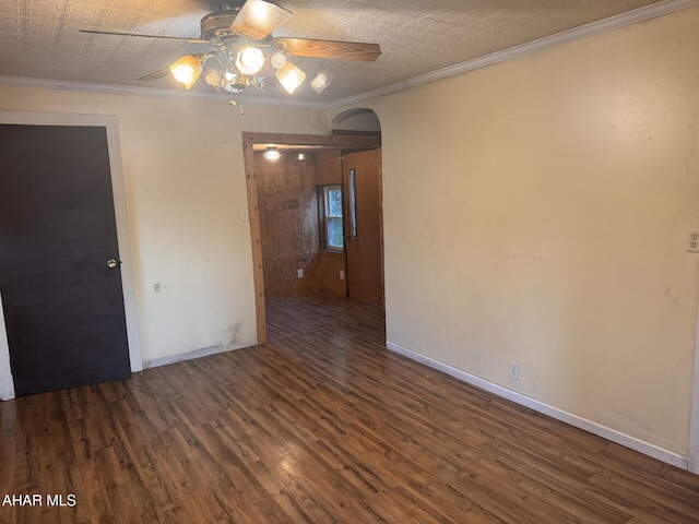 empty room featuring dark wood-type flooring, ceiling fan, and ornamental molding