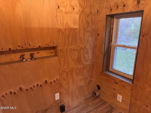 washroom with hardwood / wood-style floors and wooden walls